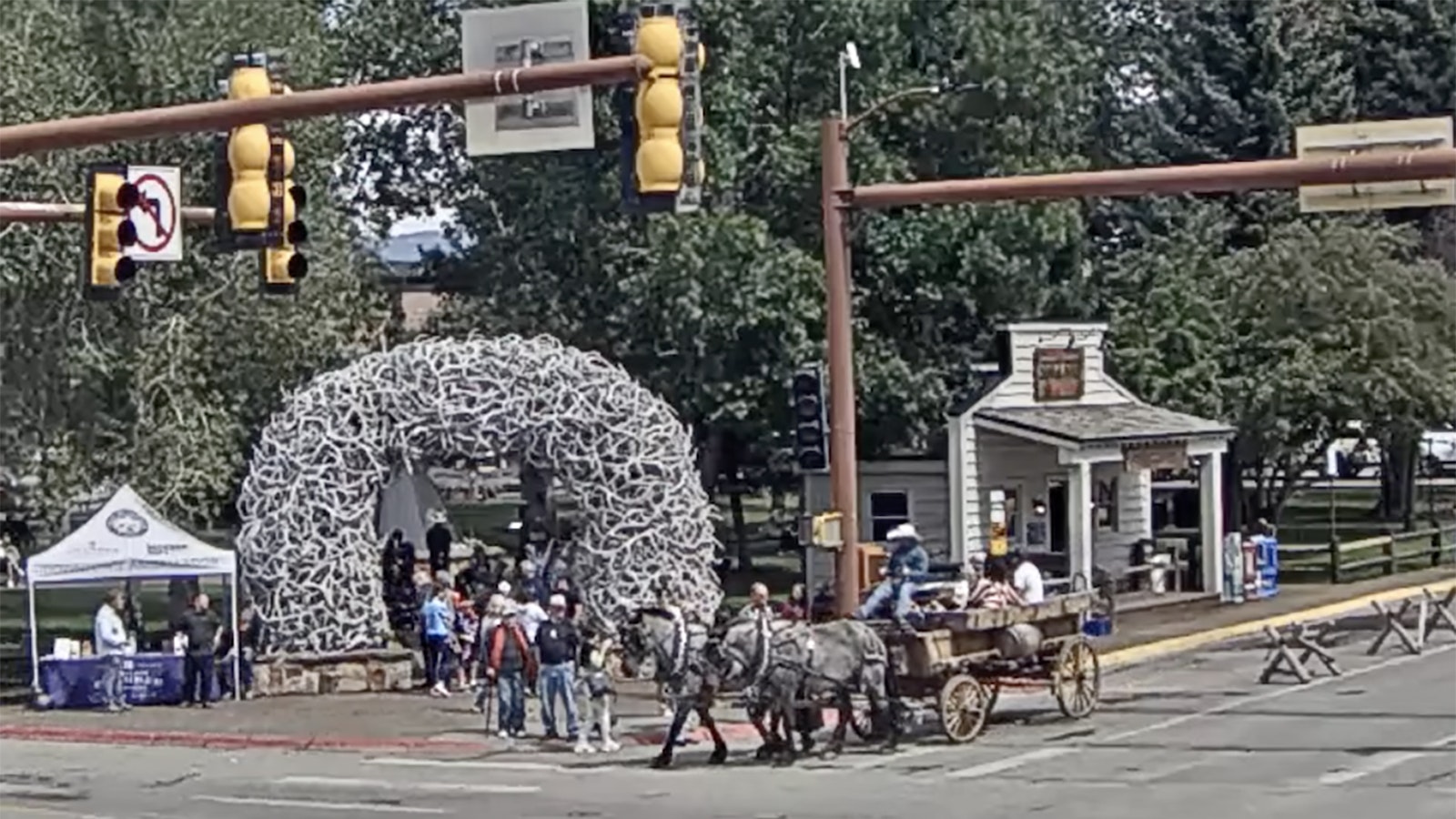 A hay wagon makes its way through downtown Jackson a week after a runaway team of horses crashed an unoccupied stagecoach into a light pole at the town's busiest intersection.