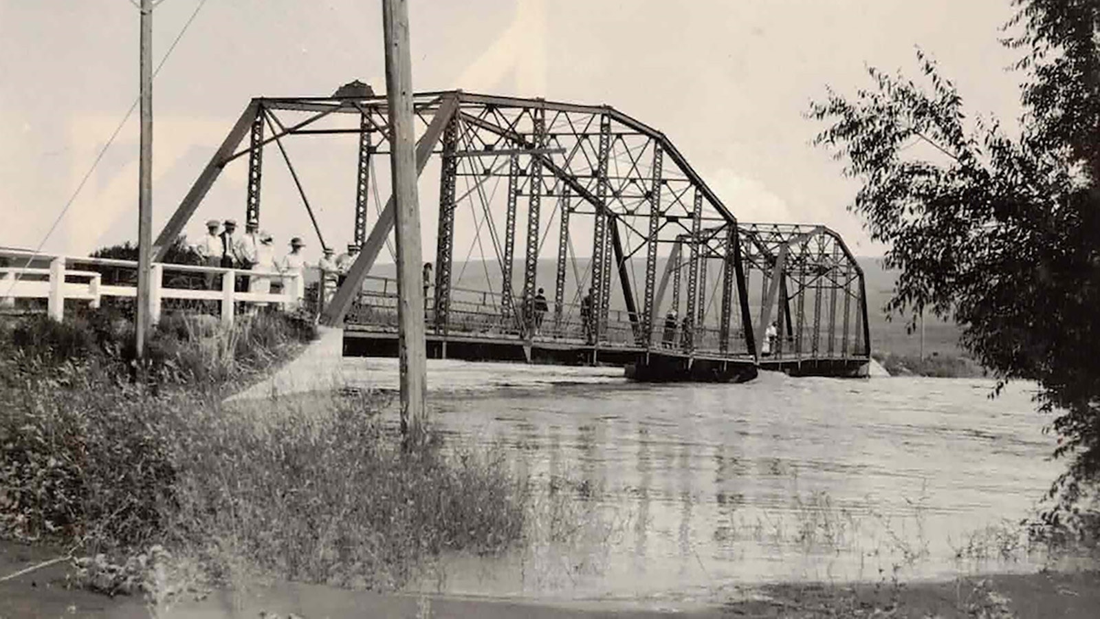 In July 1923, the Bighorn River Basin became filled with water through torrential rains. Here Thermopolis residents stand on a bridge as the waters rise on July 24, 1923.