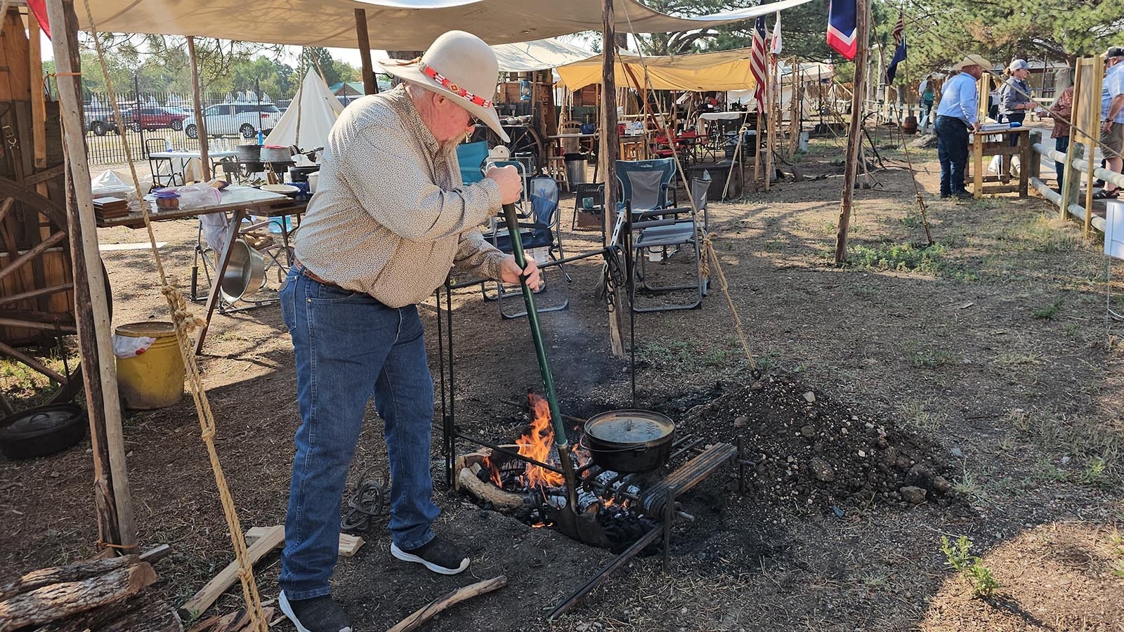 Rich Herman tends the fire while reheating some of his first-place winning chicken-fried steak the morning after the chuckwagon cookfoff.