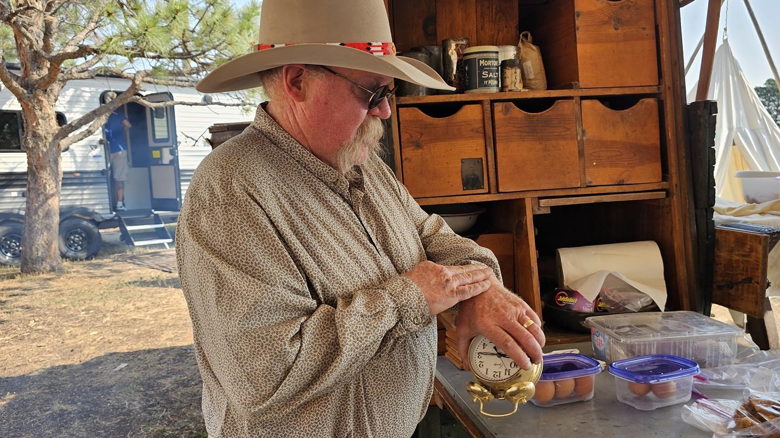 Rich Herman winds up his old-fashioned clock so he can keep tabs on cooking times with just a glance.