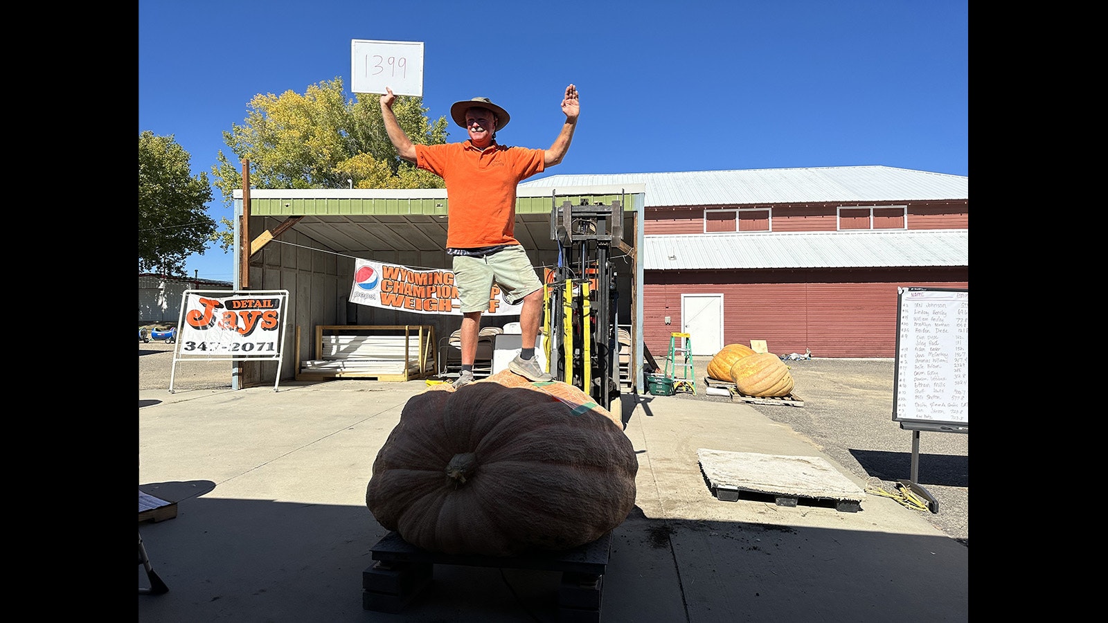 Jay Richard celebrates winning with a 1,399-pound pumpkin.