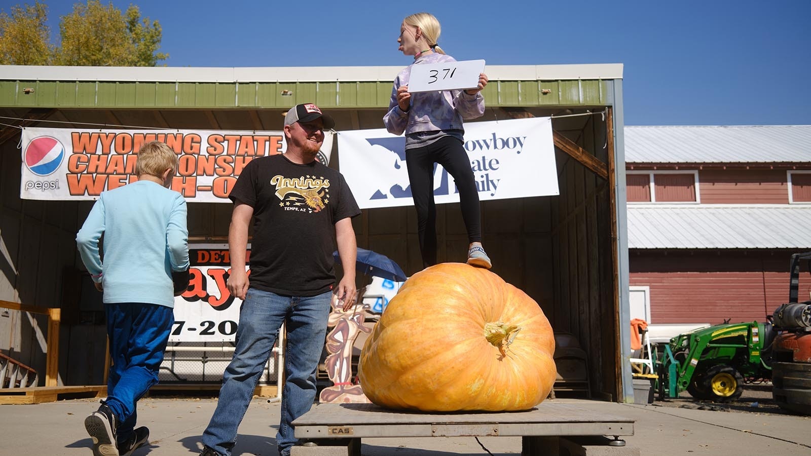 Ten-year-old Joley Reid makes a silly face at Dustin and Grady Reid. She won the giant pumpkin youth competition at the 2024 Wyoming State Pumpkin Weigh-Off Crowd on Oct. 5, 2024.