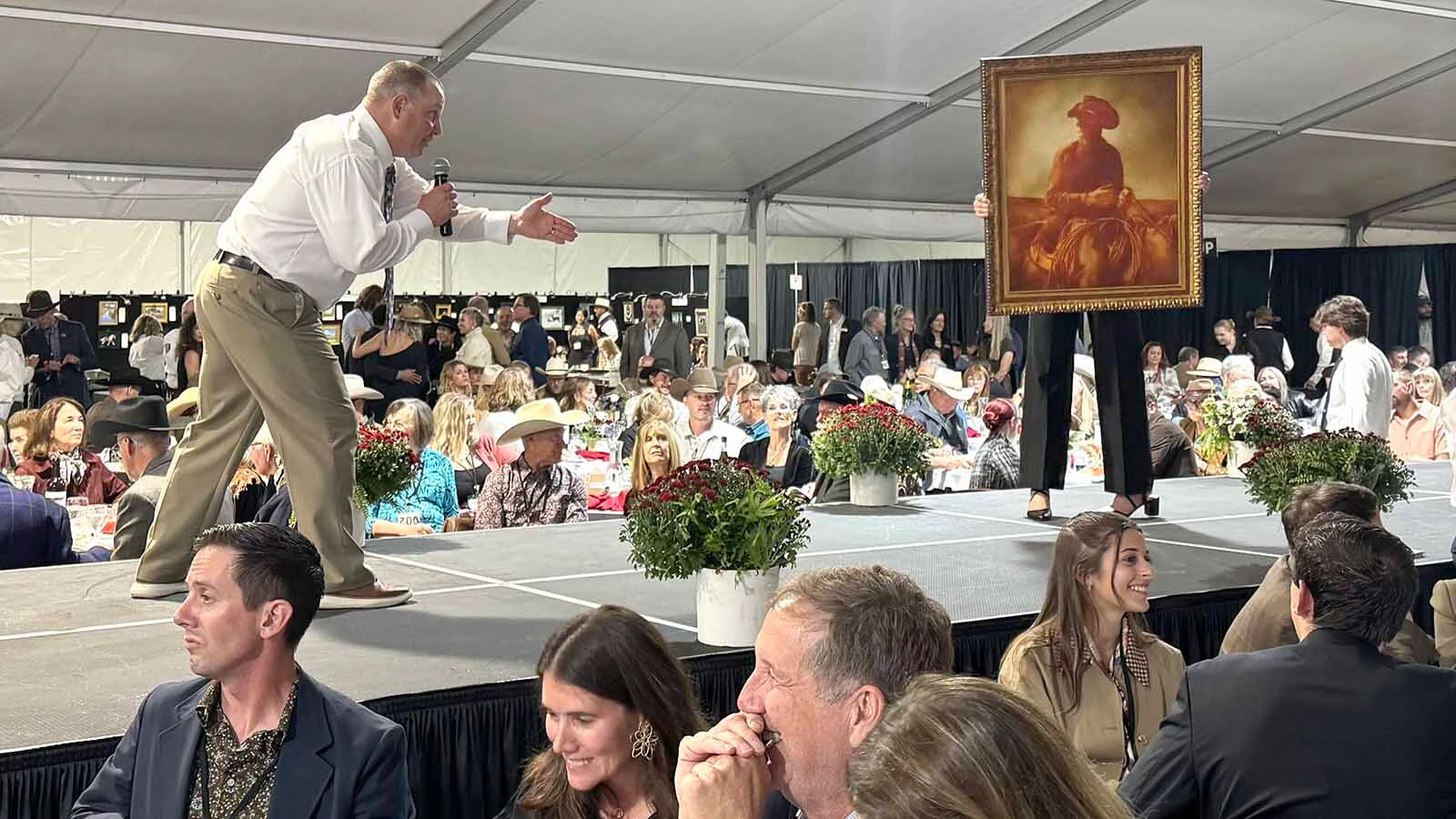 Auctioneer Troy Black keeps bidders laughing and partially in the dark during the 45th Buffalo Bill Art Show and Sale. 