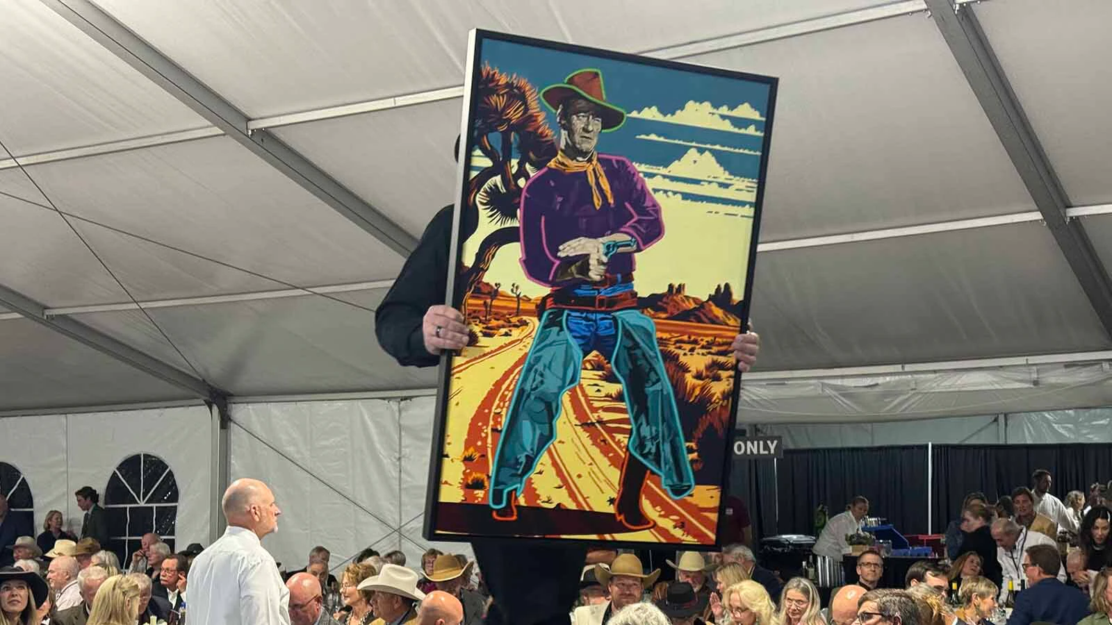 "Not On My Watch," an oil painting by Michael Blessing, makes its way down the runway during the 45th Buffalo Bill Art Show and Sale on Friday. The painting sold for $12,000. 
