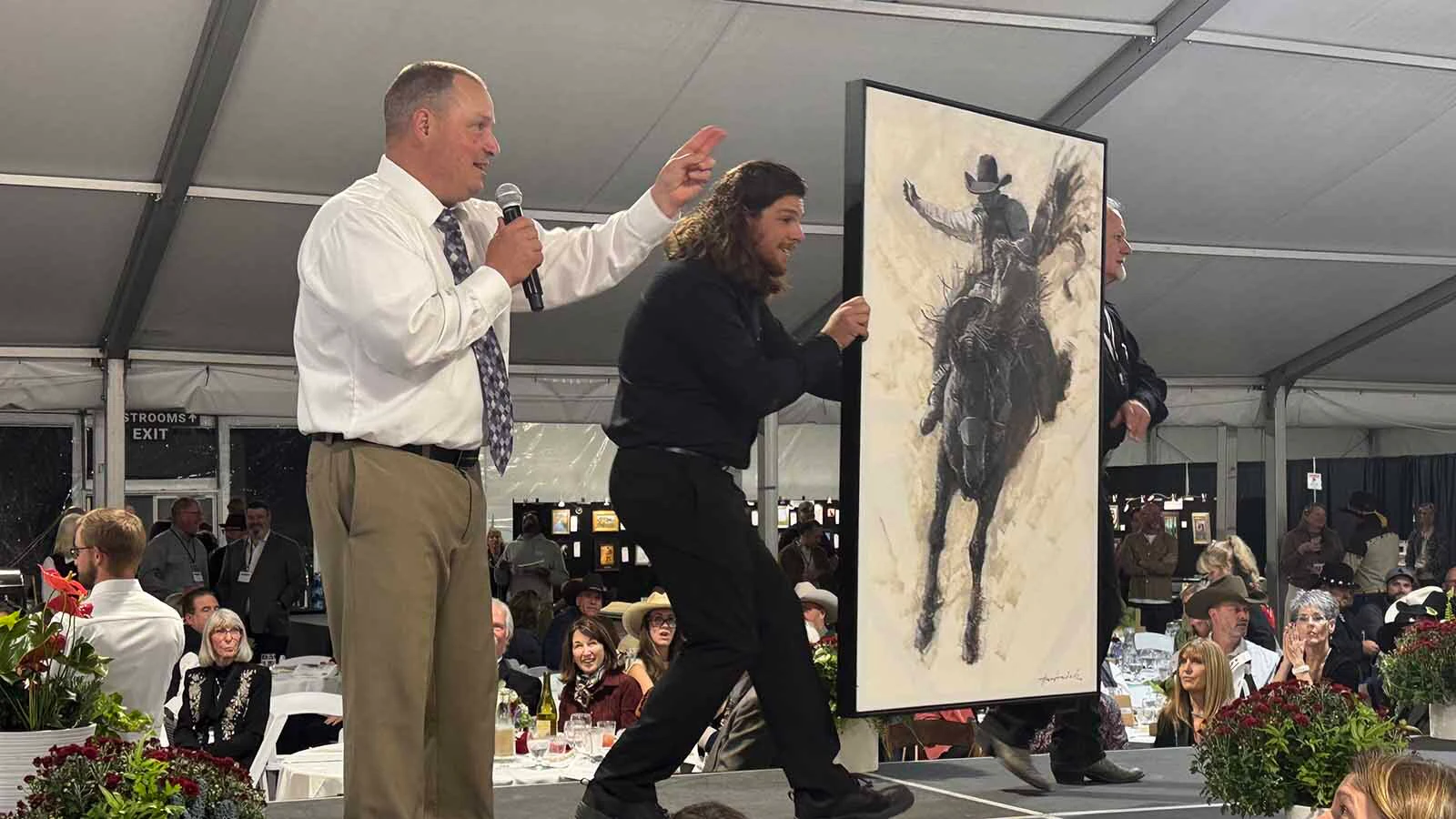 Auctioneer Troy Black keeps bids coming in for "High Ride," an oil painting by David Frederick Riley, during the 45th Buffalo Bill Art Show and Sale. 