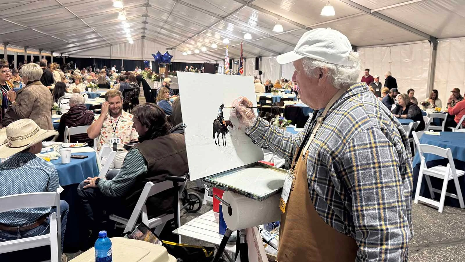 Artist Michael Ome Untiedt works on an oil painting inside the big tent during the 45th Buffalo Bill Art Show and Sale's Quick Draw on Saturday.