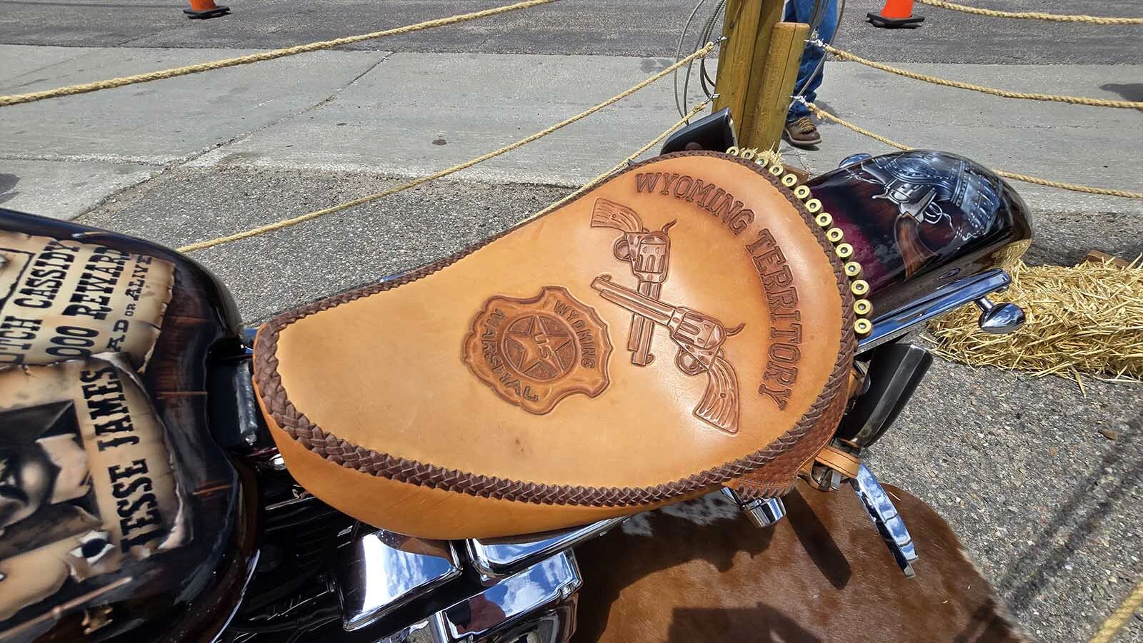 The seat for the Wanted Dead or Alive bike is a leather saddle, with crossed pistols and an old-timey marshals badge. A row of bullets accents the braided edging.