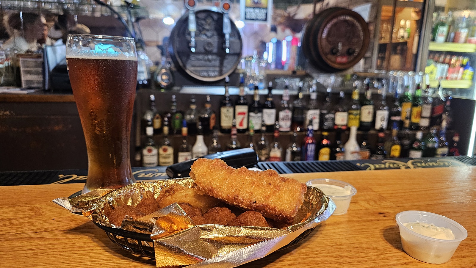 The bar serves baskets of fish, shrimp, or chicken strips. A variety of fried sides are also available, like these mushrooms, pictured with a beer from Wyoming brewer Black Tooth Brewing.