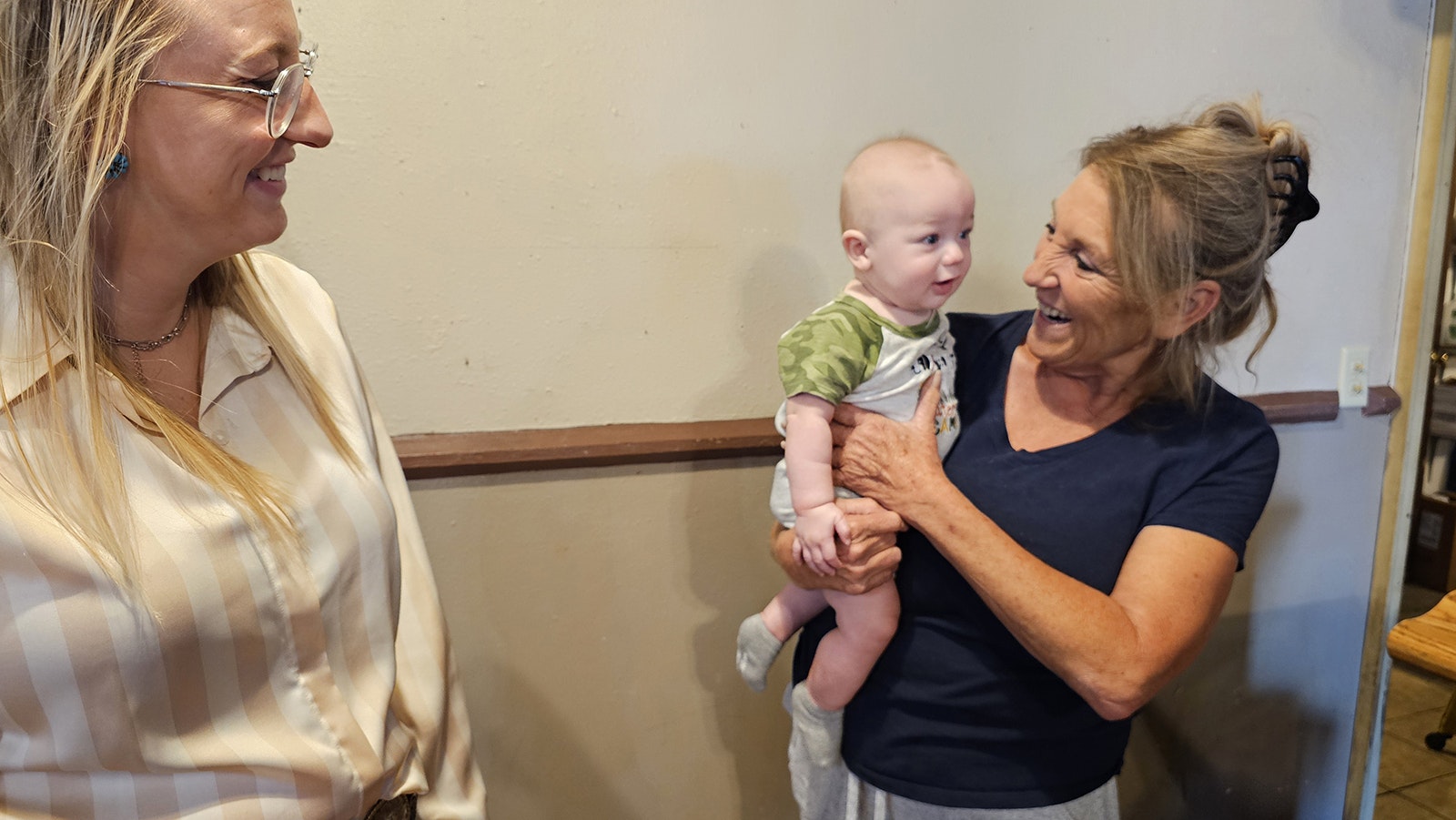 Shirley Bullock holds her grandson as her daughter Avy Emerson looks on.