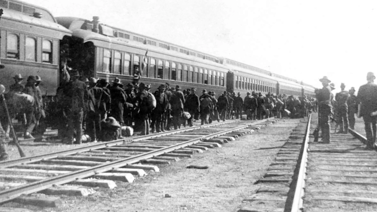 With federal troops standing guard, members of Coxey's Army board a train in Green River for Idaho, where they were all found guilty of stealing a train and given minor sentences.