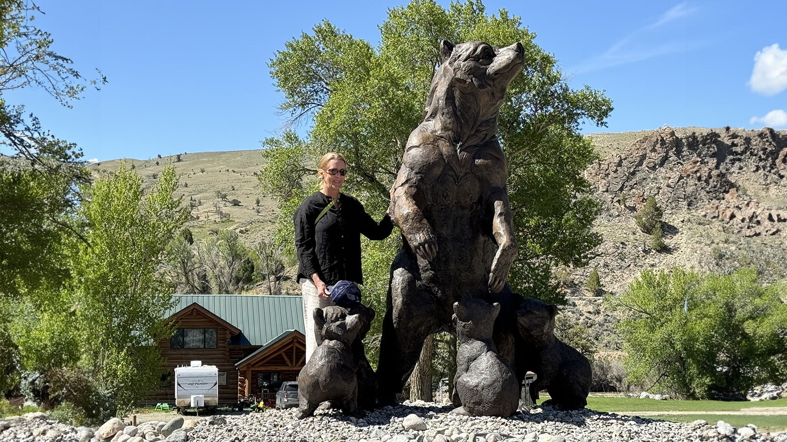 Someone poses next to the bronze sculpture of Grizzly 399. The sculpture was created at Eagle Bronze in Lander.