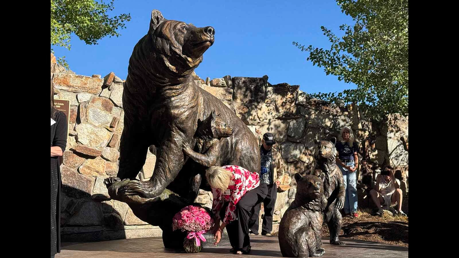 Bronze sculptor Jocelyn Russell places a vase containing 39 roses and four carnations at the feet of Grizzly 399. Russell spent 22 months sculpting the larger-than-life memorial to the famous grizzly.