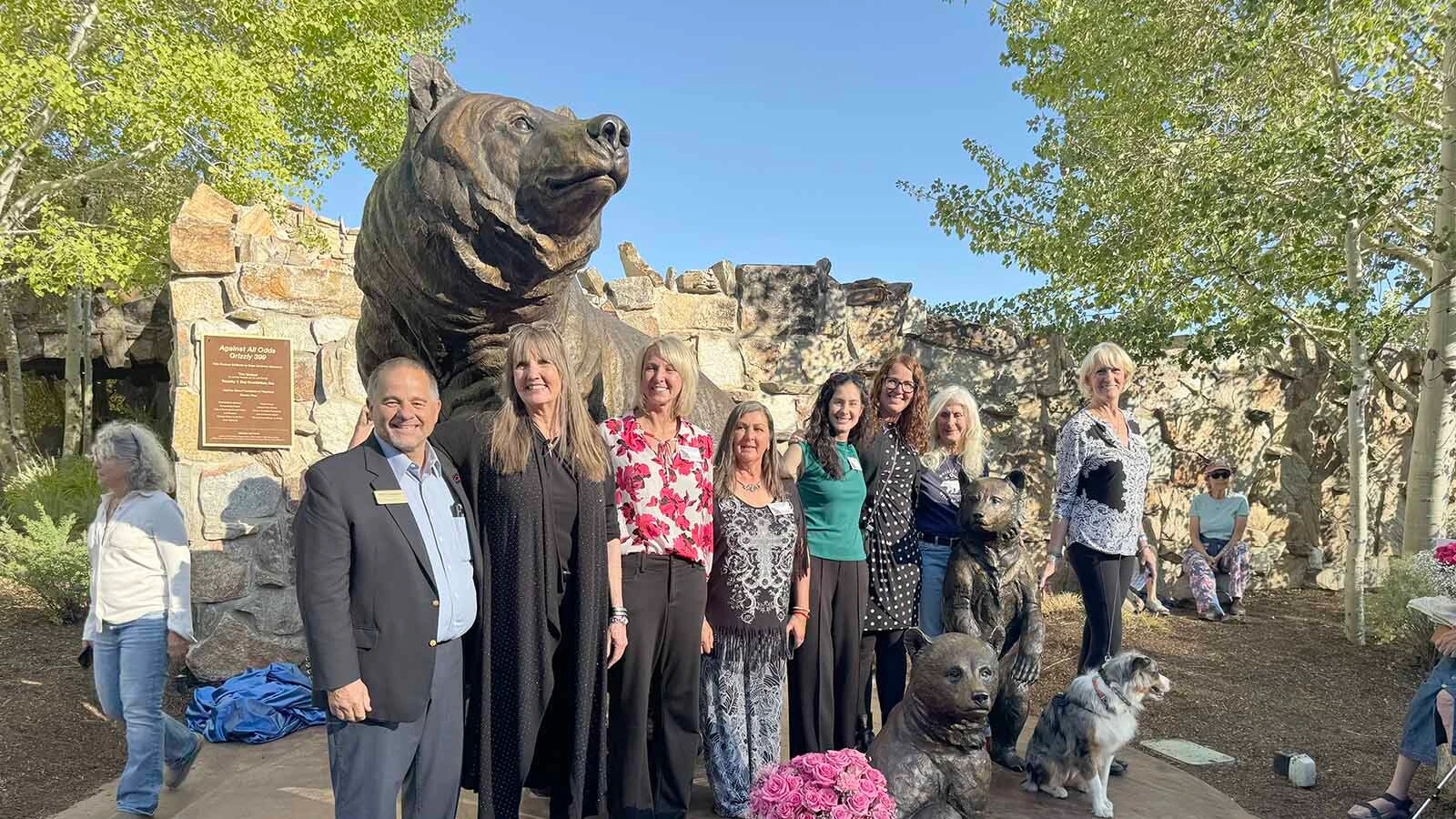 Several key people, including sculptor Jocelyn Russell, pose in front of the newly-unveiled bronze sculpture of Grizzly 399.