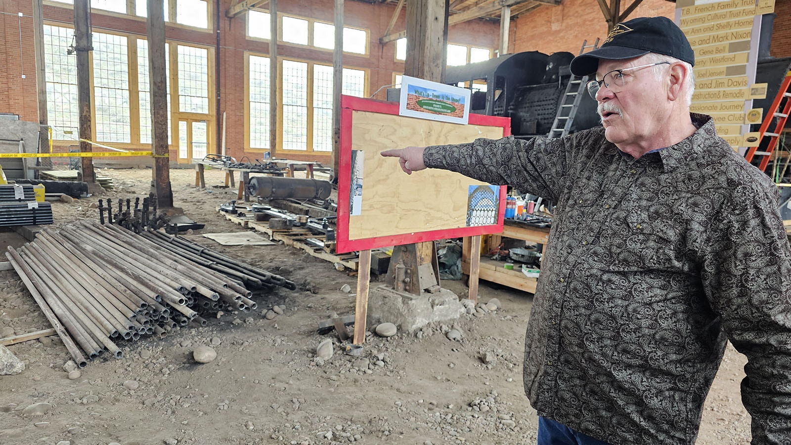 Steve Ewing points at steel tubes that were taken out of the 4420 steam engine and must be replaced with new.