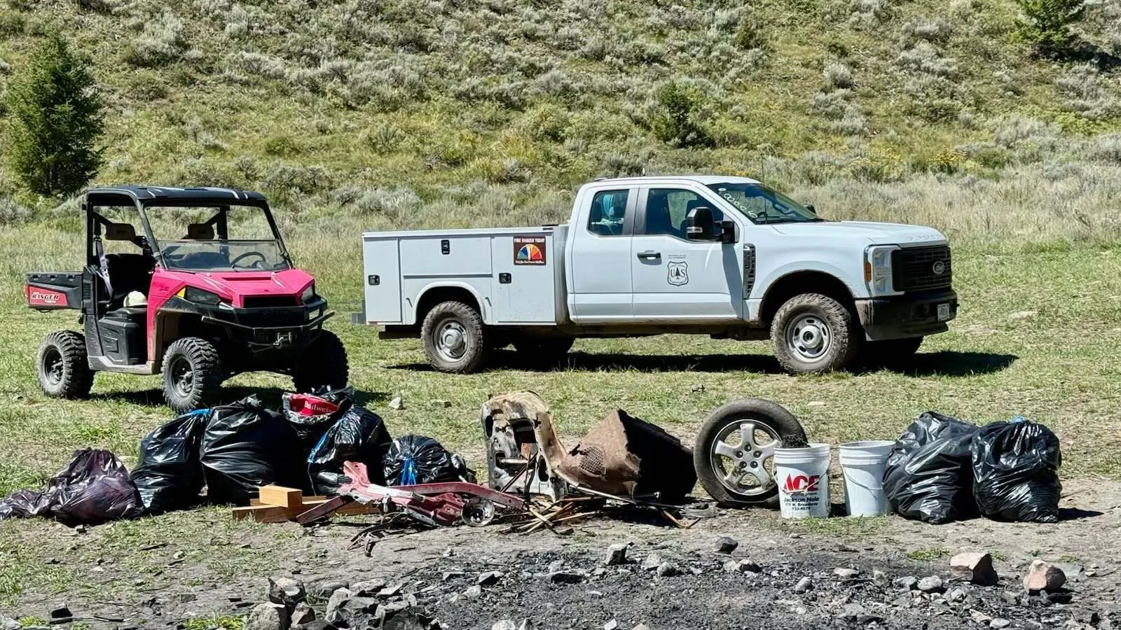 Bags of garbage, a tire and pieces of a vehicle are among debris collected during a cleanup at the Fall Creek dispersed campsite. 