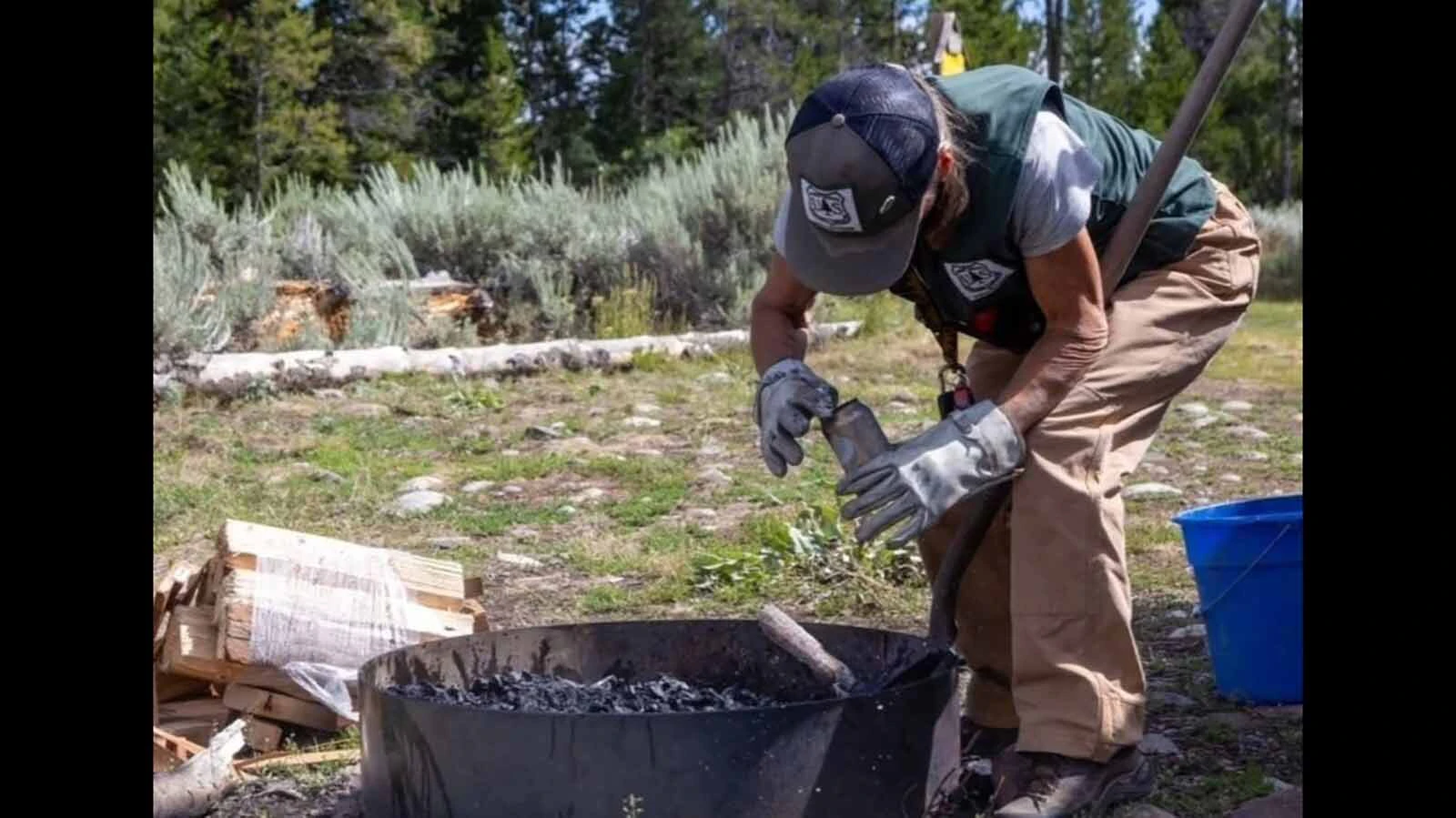 A Friends of Bridger-Teton volunteer ambassador tends to a fire ring while working in the Bridger-Teton National Forest. Ambassadors monitor dispersed camping areas for problems including abandoned fires, trash and improper food storage.