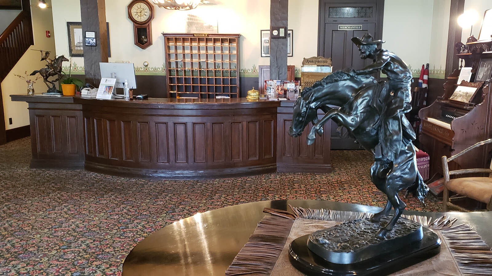 A galloping horse sits on the piano while behind the original desk and mailbox for the inn.