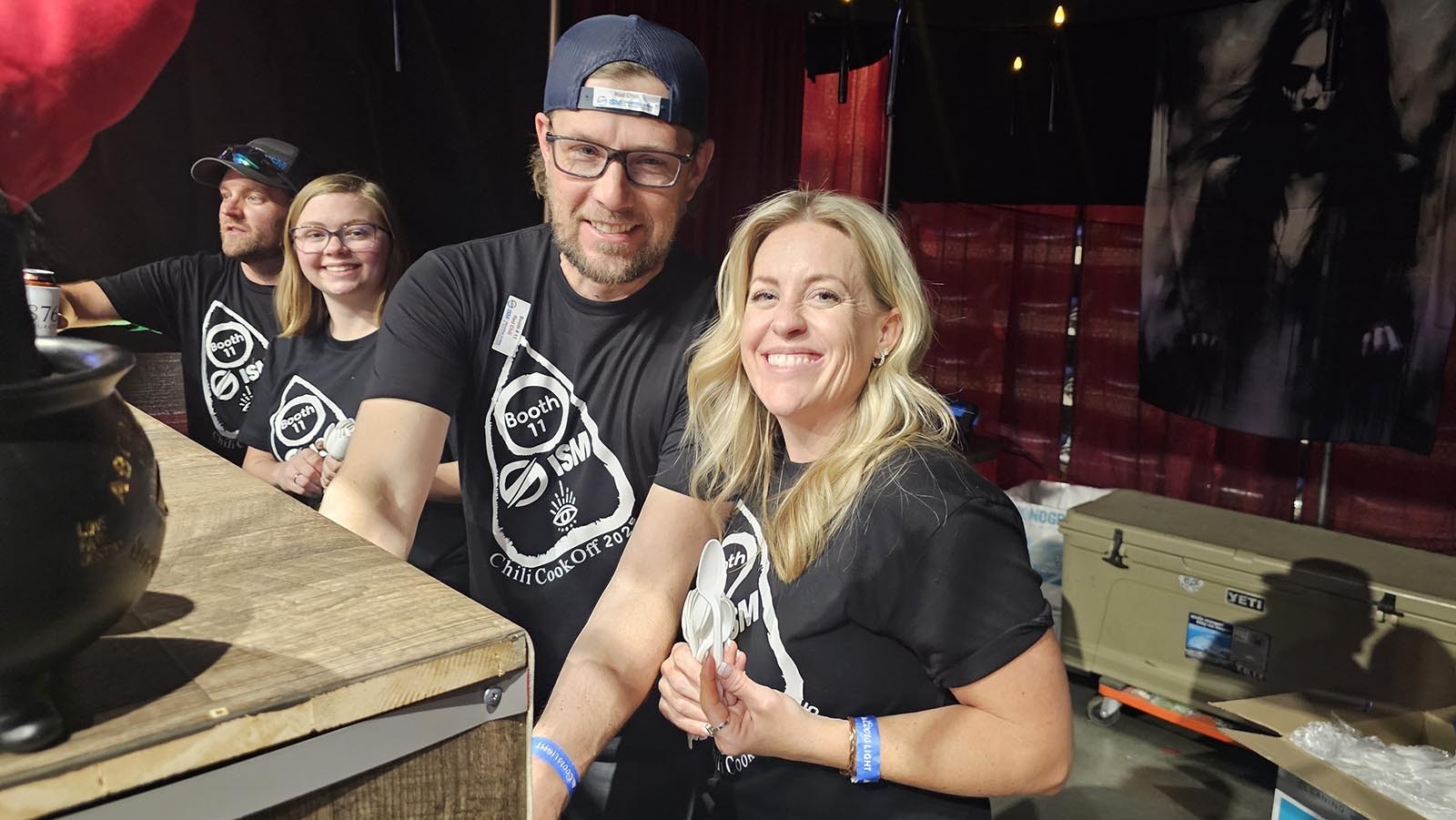 Lindsey Robinson, right, smiles as she hands out spoons at the Industrial Screen and Maintenance booth during the API Chili Cook-Off in Casper.