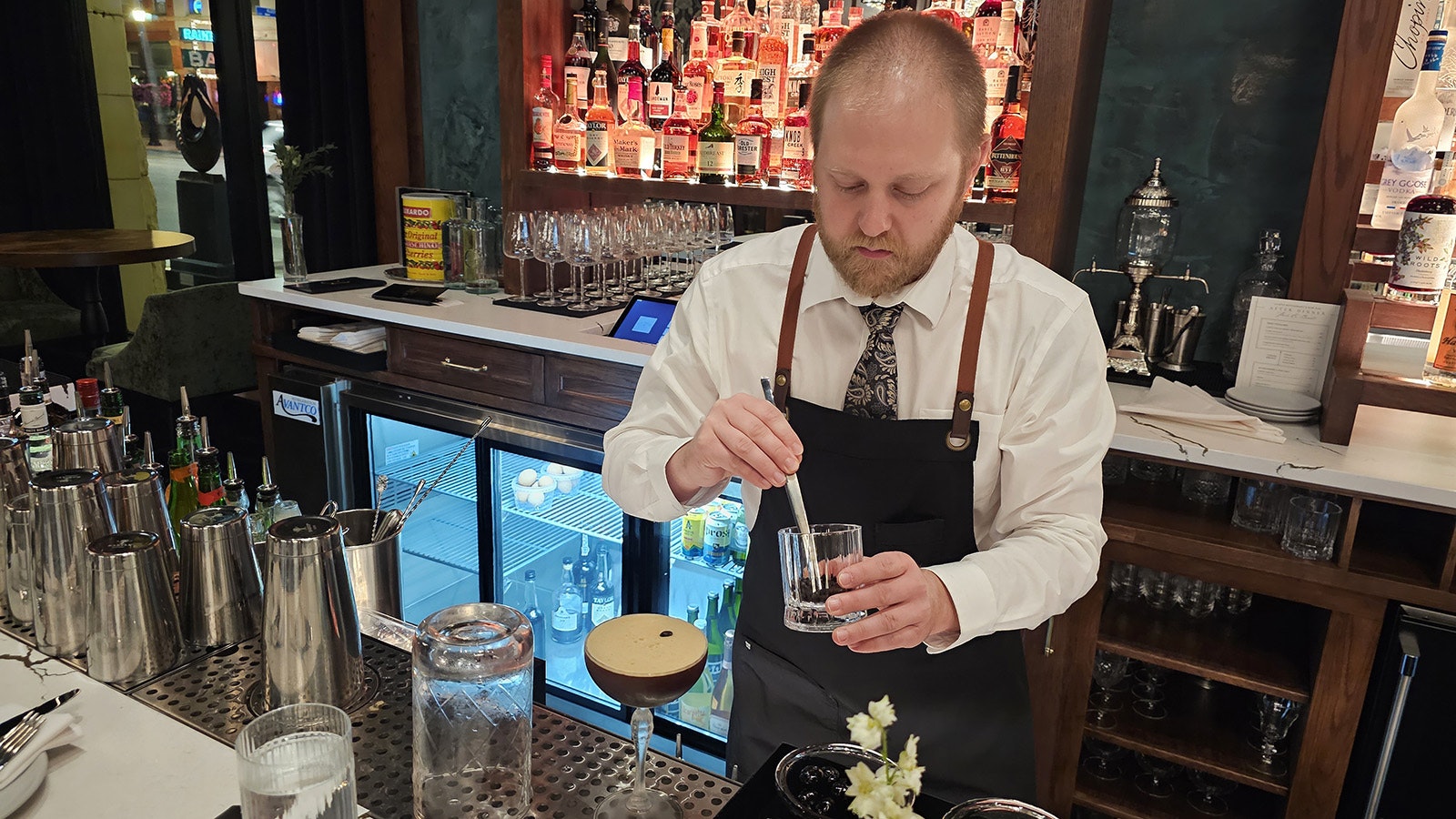 A number of cocktails are available at   Le Reve Restaurant & Raw Bar in Sheridan. In the photo, a bartender garnishes an espresso martini with coffee beans.