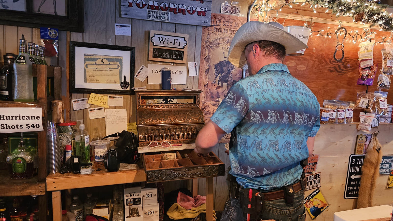 Trent Tope makes change using the old cash register in the Aladdin General Store's bar.