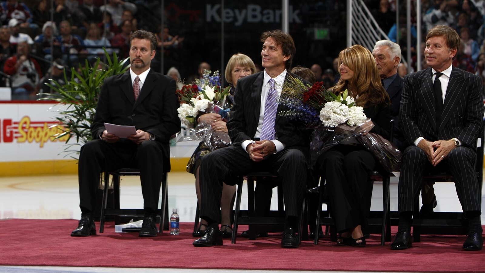 Alan Roach, left, sits next to Colorado Avalanche star Joe Sakis during a 2009 ceremony to celebrate Sakic's retirement. Also pictured are Sakic's wife, Deb, and team owner E. Stanley Kroenke.