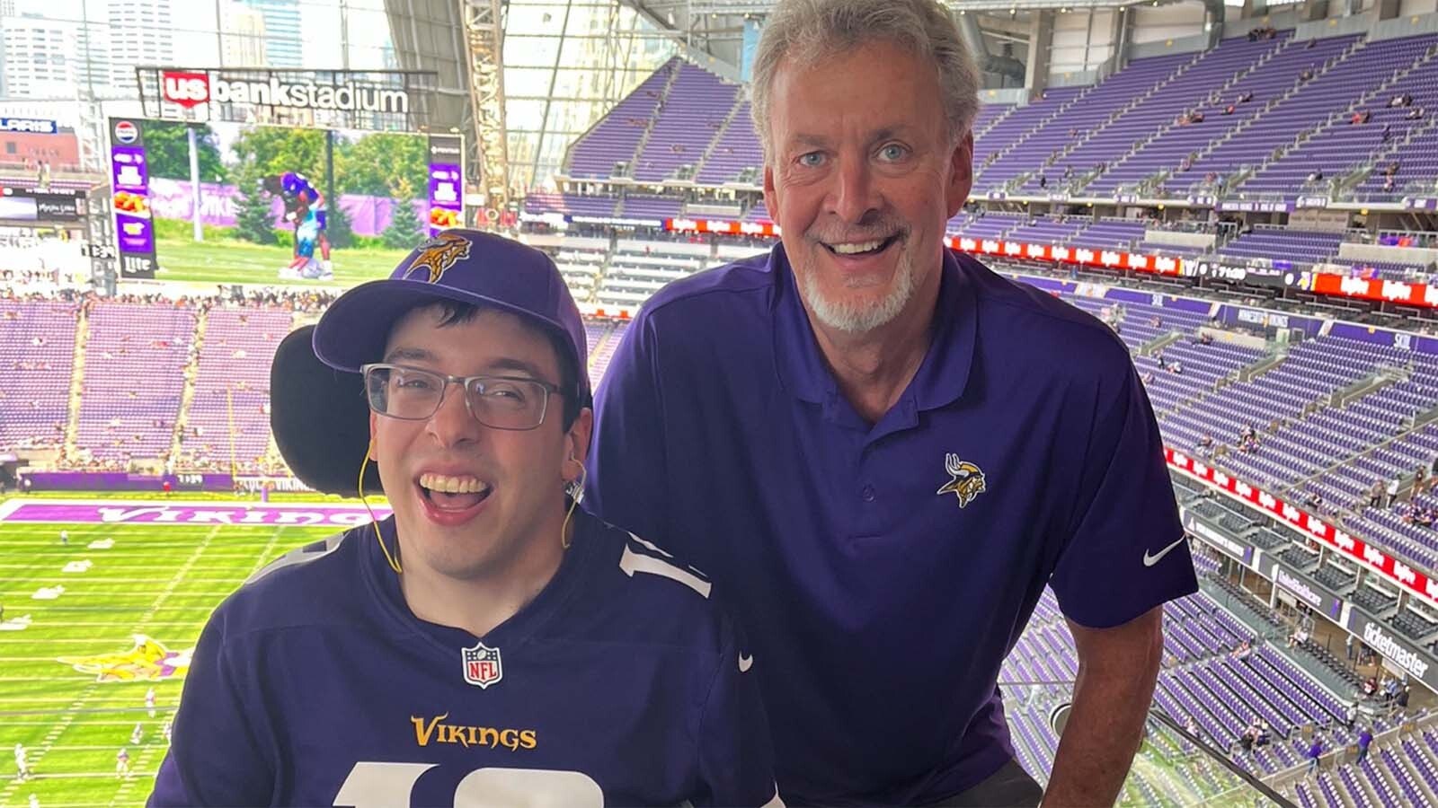 Alan Roach in the broadcast booth with a Minnesota Vikings fan.