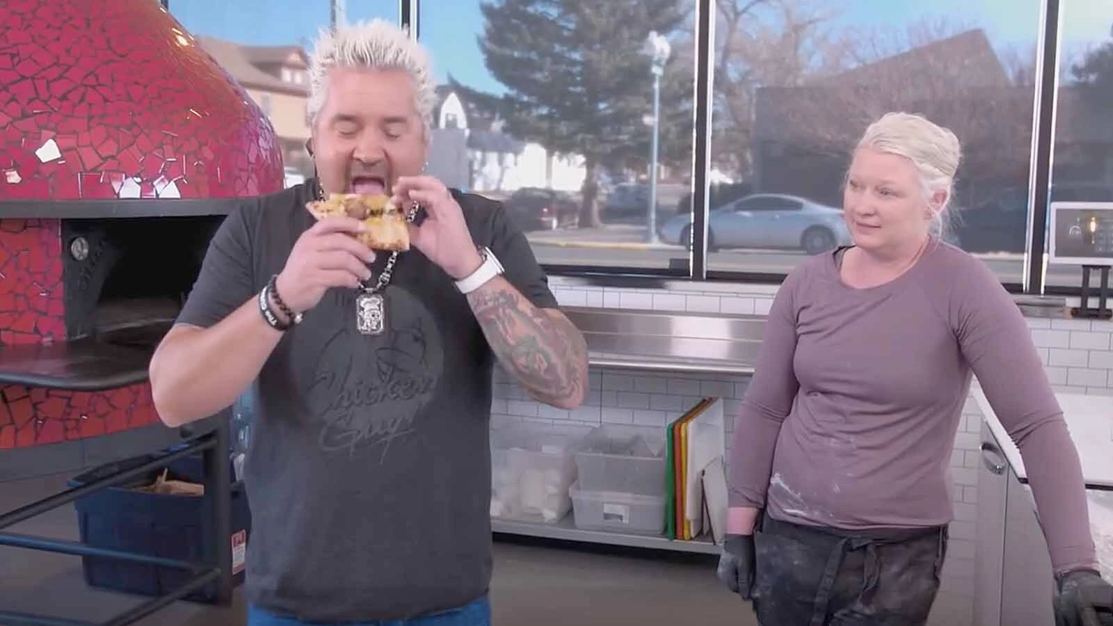 Guy Fieri tries the signature beef brisket pizza at Alibi Wood Fire Pizzeria & Bakery in Laramie with co-owner and chef Kerri Smith looking on. Alibi was featured on "Diners, Drive-Ins & Dives" in 2022.