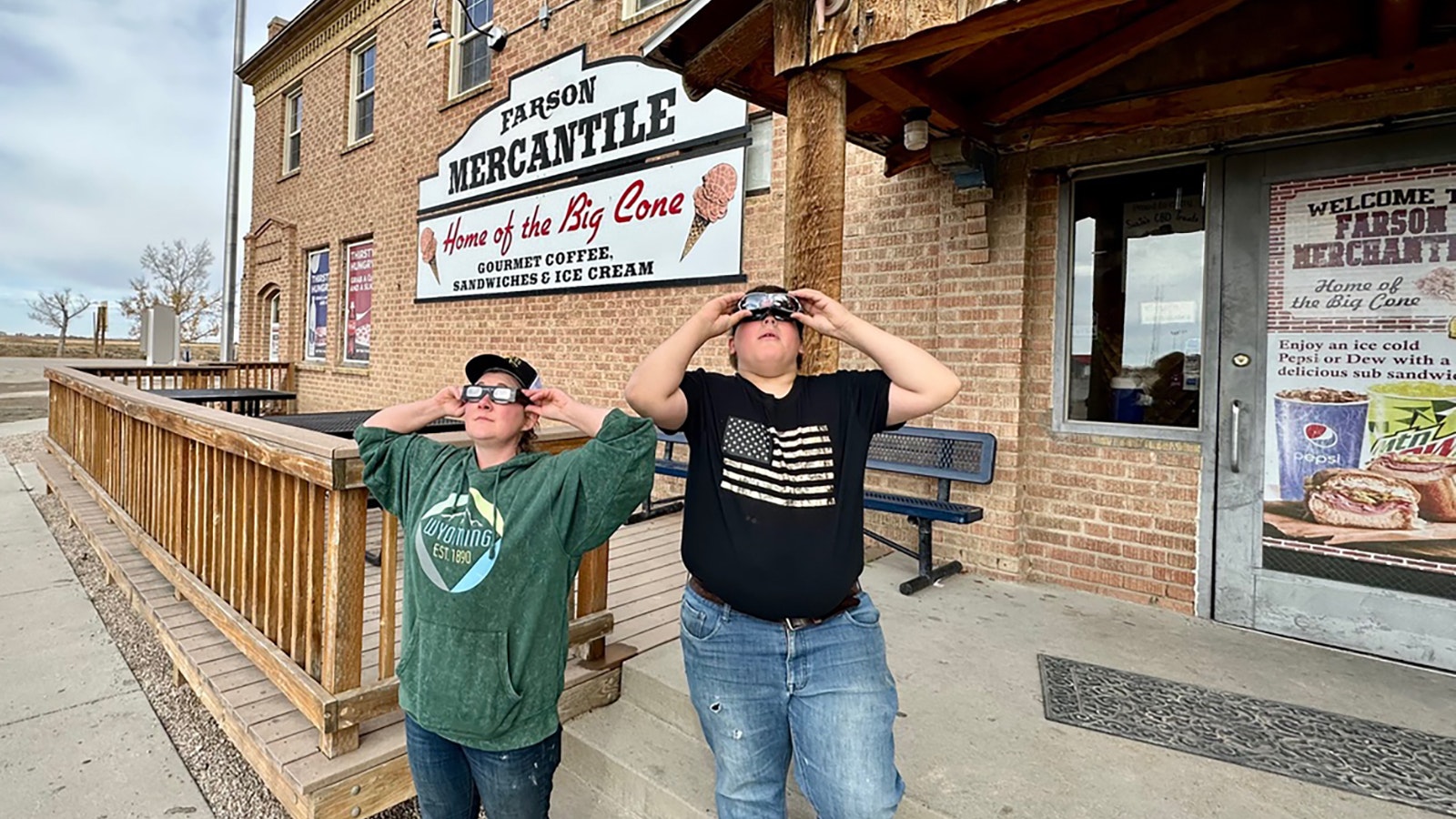 Alli Roghair and Bryce Campbell watch Saturday's eclipse from in front of the Farson Mercantile.
