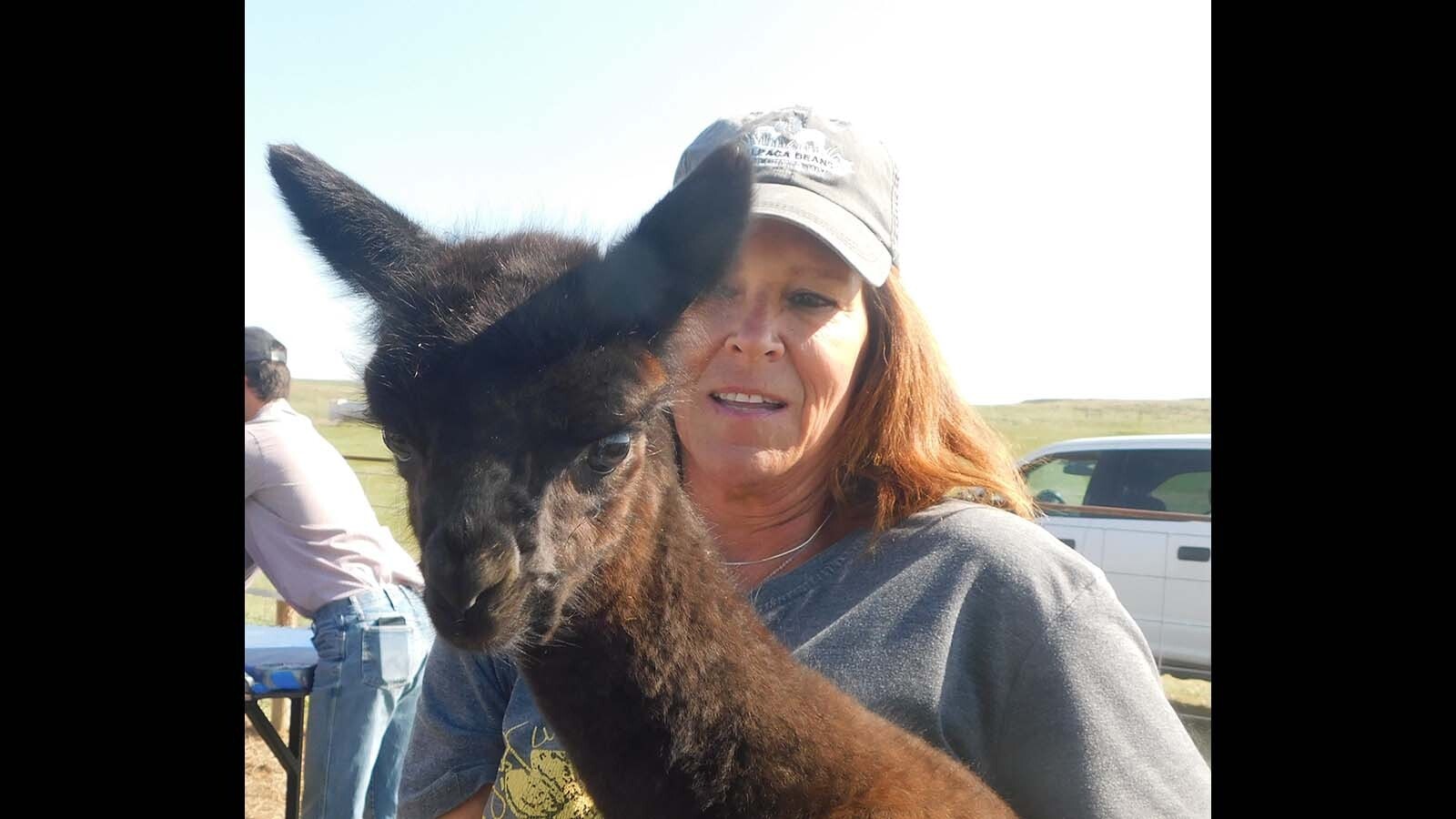 Heidi Nation holds one of the baby alpacas.