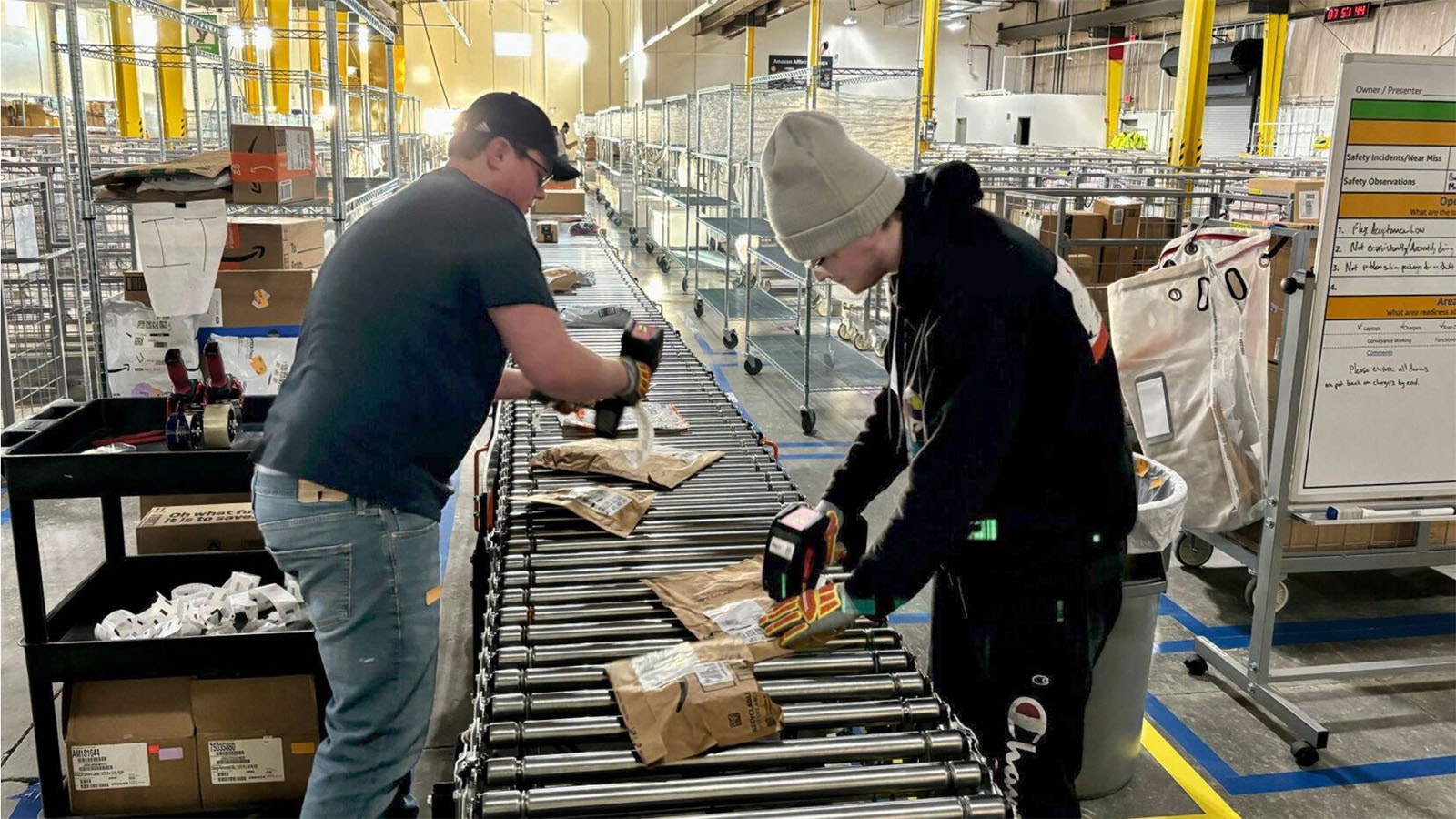 Workers at the Casper Amazon Flex location sort packages for delivery.