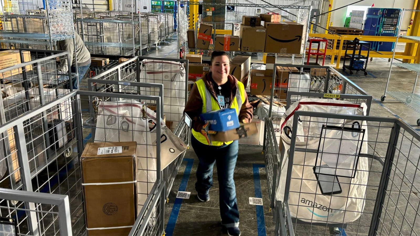 Workers at the Casper Amazon Flex location sort packages for delivery.