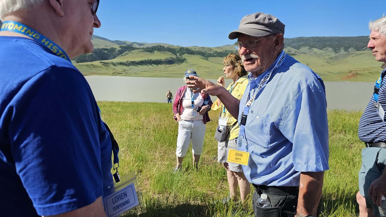 John Visit, right, answers questions about Anchor Dam, in the background.