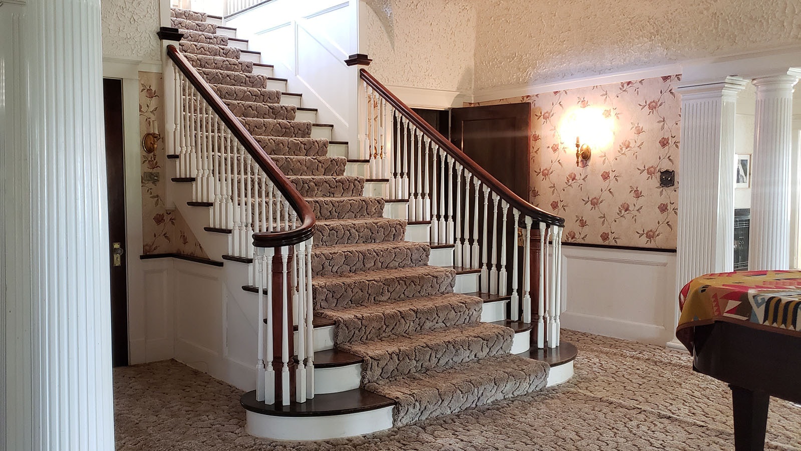 A grand staircase in the entryway leads up to spacious bedrooms at the Arapaho Ranch.