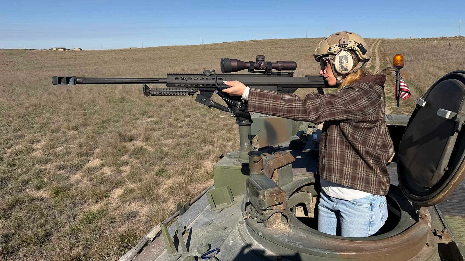 Cowboy State Daily reporter Kolby Fedore tries out the position behind a mounted rifle on Pirado's Spartan during an October visit to his property outside Glendo.