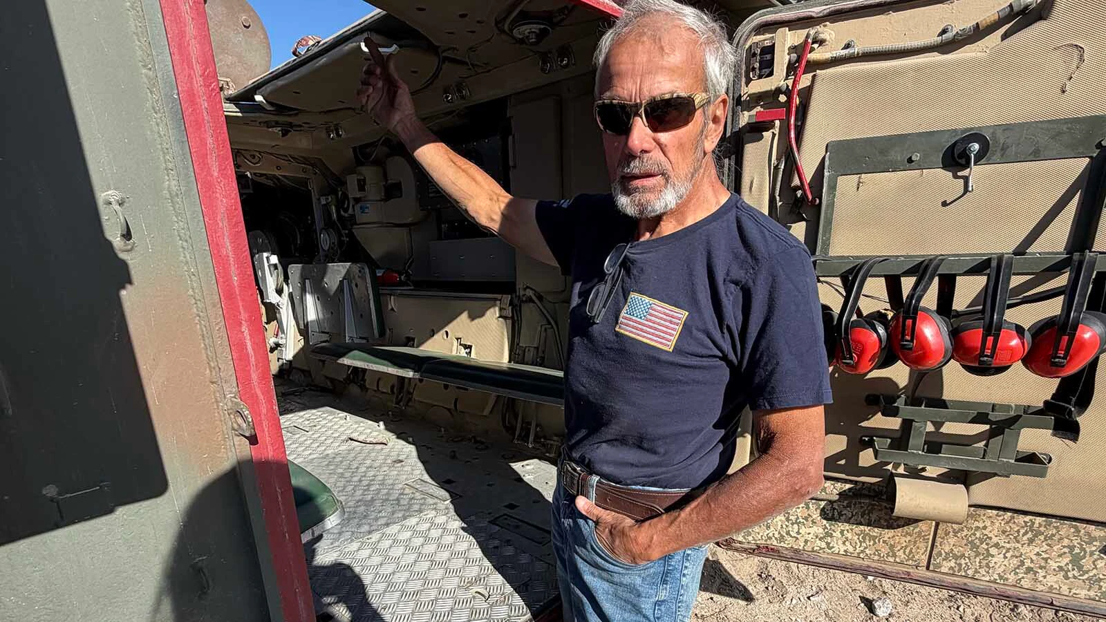 Pedro Pirado stands at the open hatch of one of the old military vehicles he keeps running at his property near Big Sandy Lake.