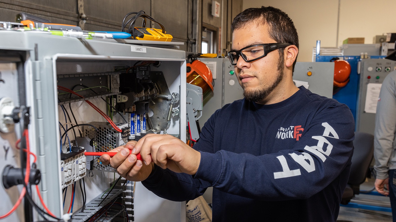 Aryah Ybarra works on his capstone project, which is an electrical circuit he built. H\is instructor will introduce faults into it for him to fix.