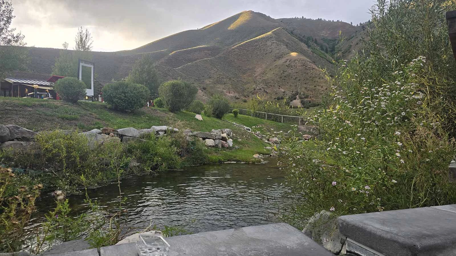 Sunlight paints the edges of the surrounding mountains with gold for just a few minutes as the sun begins to set on Astoria Hot Springs Park.