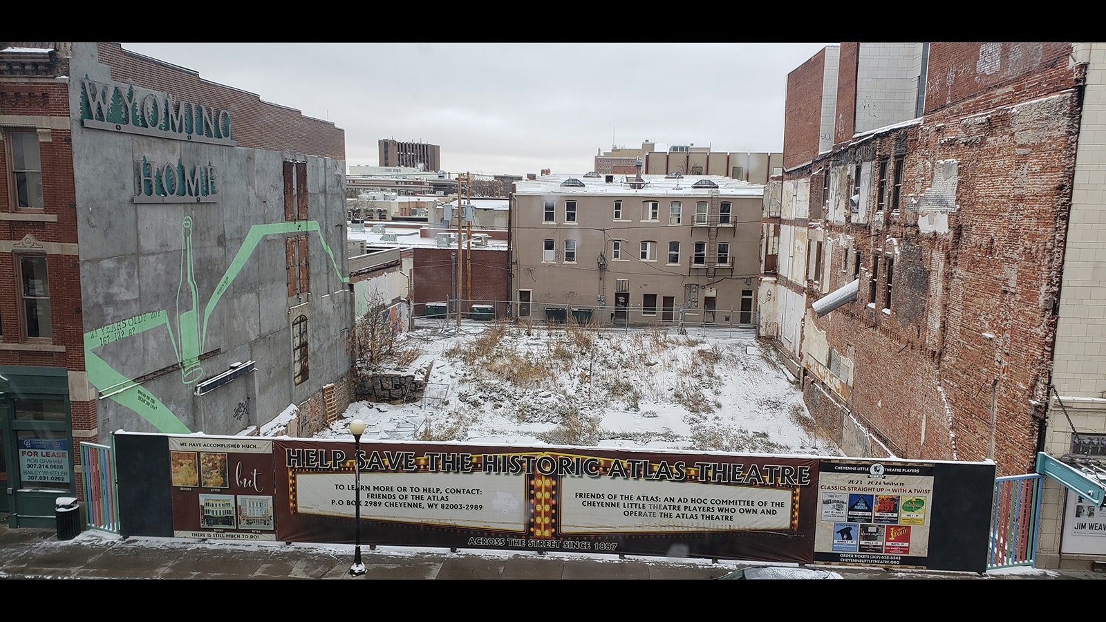 A view into "The Hole" across the street from the Atlas Theatre in downtown Cheyenne, which used to be a bakery that burnt up. Now it's cordoned off by a fence calling attention to the effort to restore the Atlas.