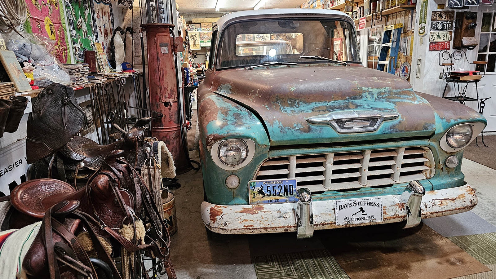 Yet another vintage truck in Dave Stephens' collection. At left, a row of saddles, and in the far corner an old-style gasoline pump.