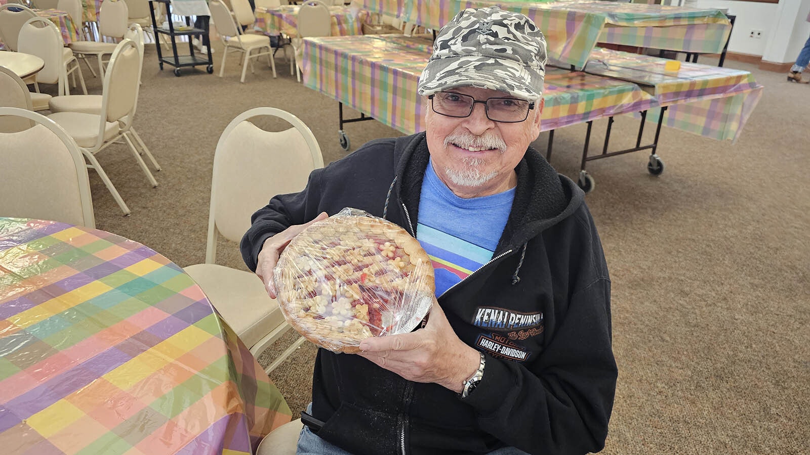 A happy pie auction customer with a sweet cherry pie.