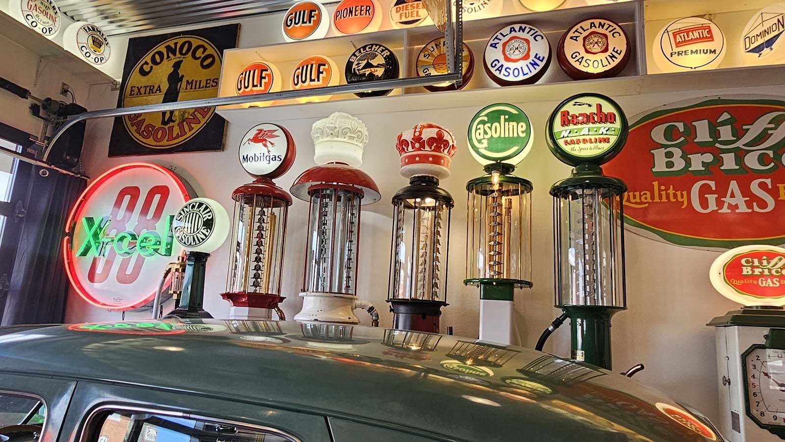Gasoline signs and gas pumps line each of the walls inside a vintage autombile-themed Airbnb recently completed by the Frontier Auto Museum.