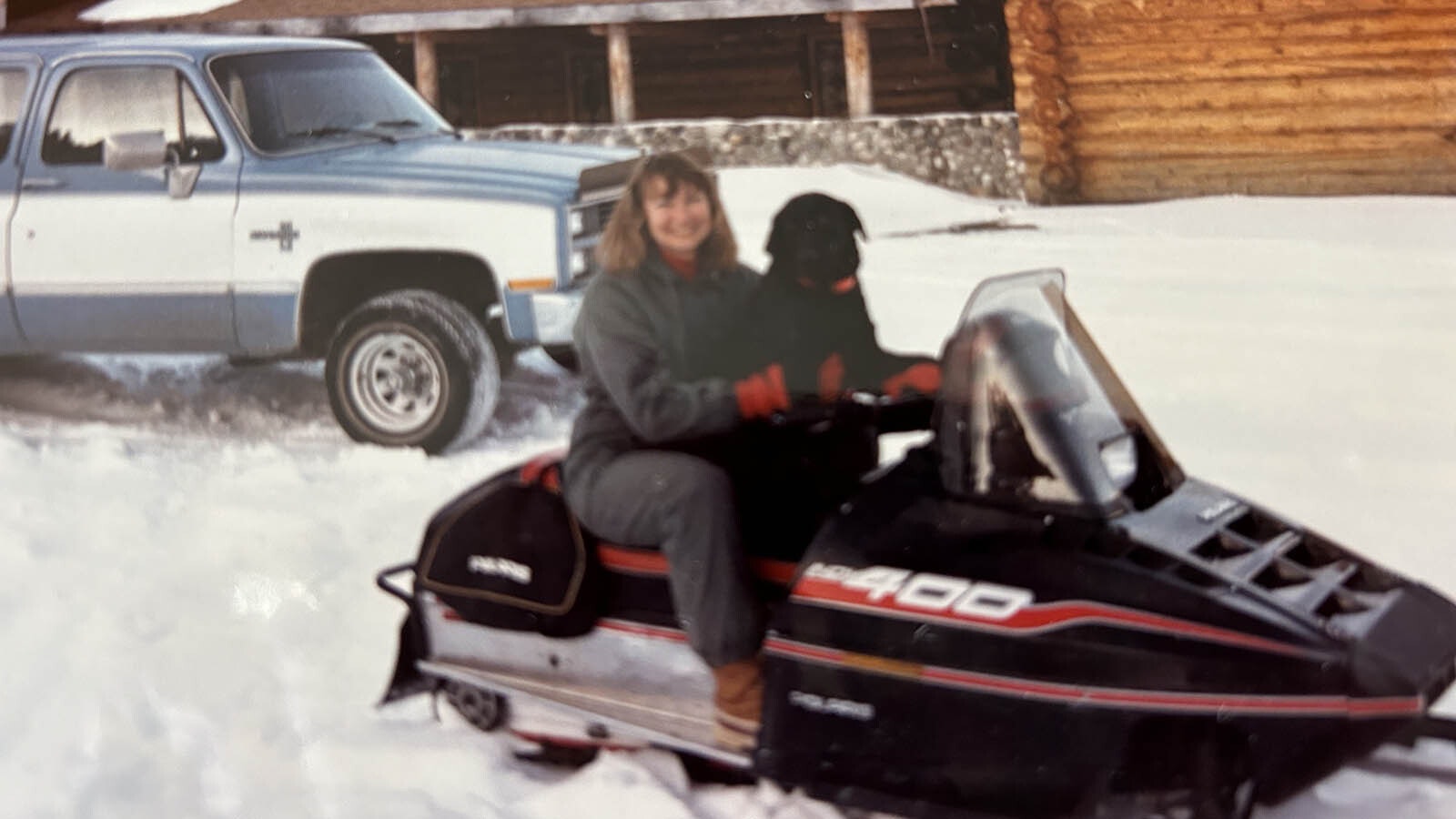 Barbara Carlsberg with her Labrador on a snowmobile.