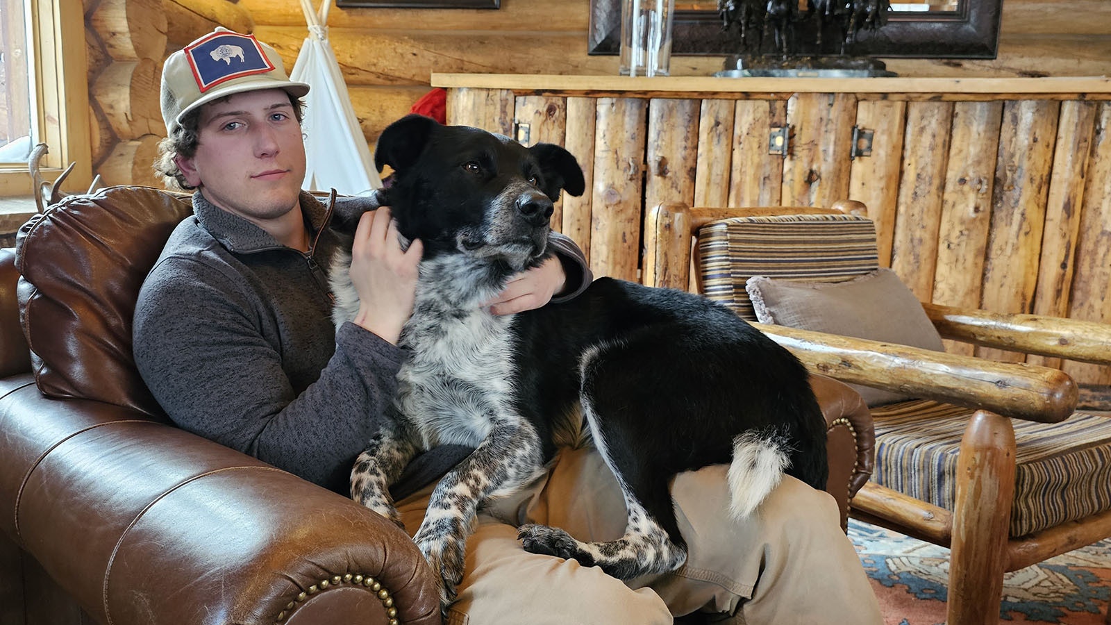 Brooks Lake Lodge guide Isaac Jones with Ranger, who is practicing to be the world's biggest lap dog.