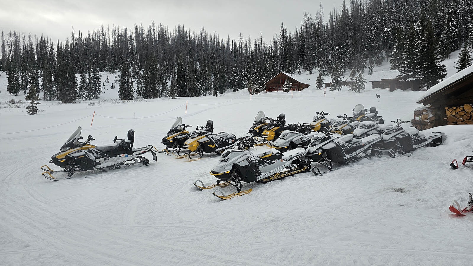 A fleet of high-performance snowmobiles at the ready for Brooks Lake Lodge guests.