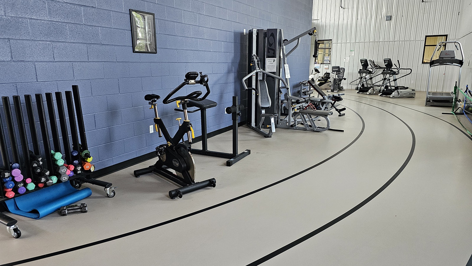 A walking track rings the basketball court that is on the other side of the concrete wall. The area also houses some of the exercise equipment at the Valley Community Center.