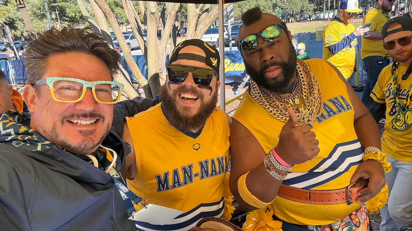 Brad Skinner as DJ Phony Stark, left, poses with the Dad Bod Cheer Squads Man Nanas Ant and Mr K during pre game festivities in Savannah, Georgia.
