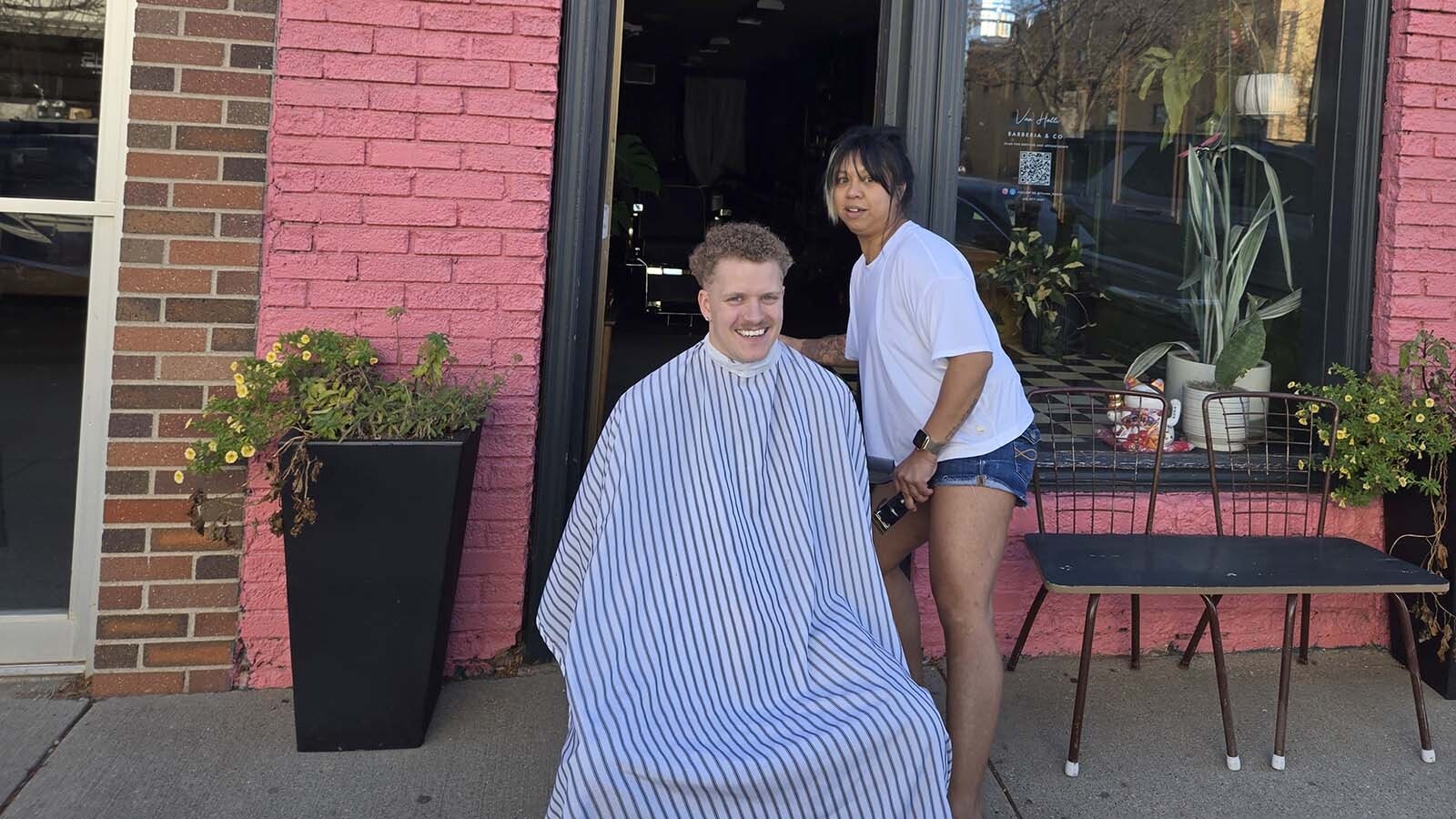 When the power went out in Rapid City, South Dakota, on Thursday, Nov. 13, 2025, Vanessa Hallinan moved Luke Higgins outside to finish his haircut.