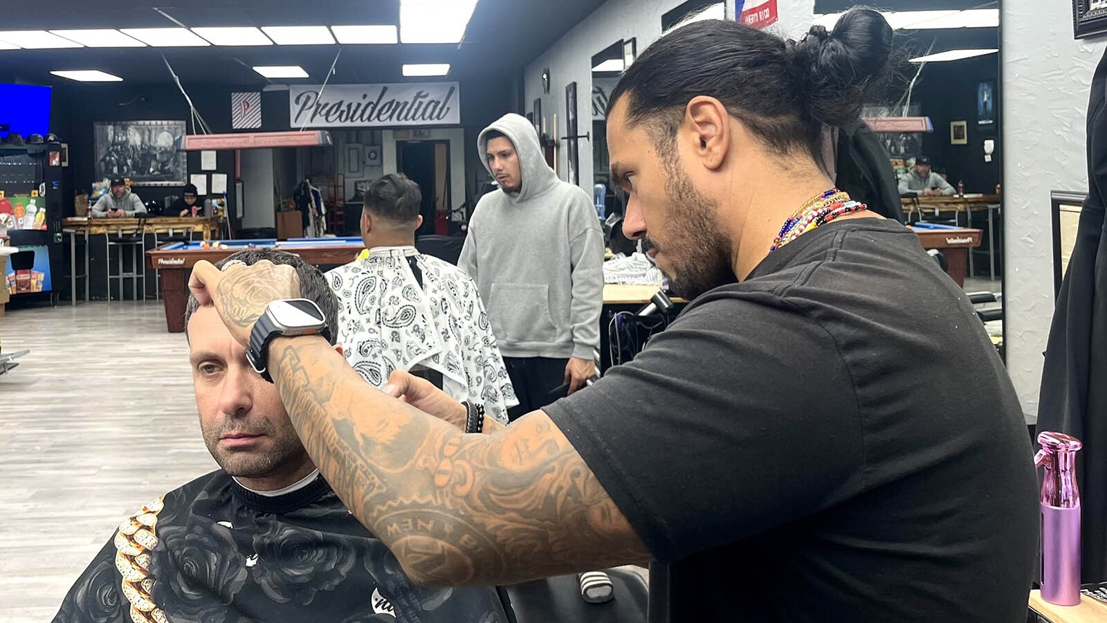 Angel Maldonado, right, of Presidential Barbershop said he general tries to avoid talking about politics when cutting hair.