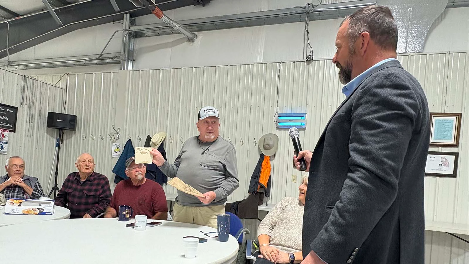 Lonnie Woodard, one of the Riverton “Gentry” coffee klatch members, presented gubernatorial candidate Eric Barlow with the state fossil, and a bit of jade as a gift after Barlow fielded questions from the group Monday