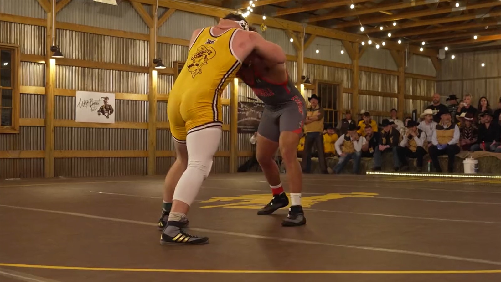A University of Wyoming grappler ties up with an opponent from Campbell University in a barn on the Deerwood Ranch in Centennial, Wyoming, dubbed "The Battle in the Barn."